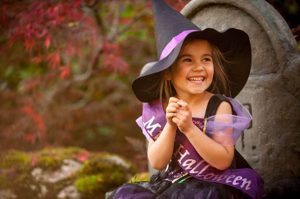 Little girl smiling in witches outfit. Halloween events on Northants Families