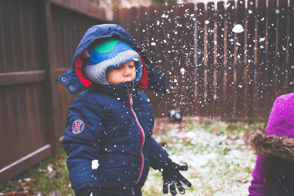 Kids playing outside in Northamptonshire engaging in screen-free play. Child playing in snow