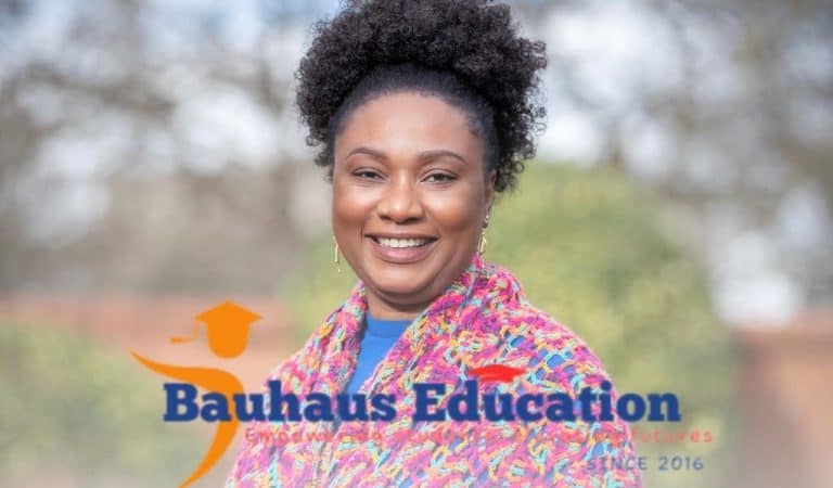Portrait of a smiling woman in a vibrant multicolored jacket, standing outside with soft-focus trees behind her and the “Bauhaus Education” branding across the image.