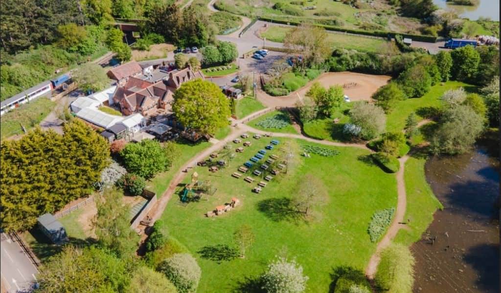 Aerial view of Brampton Halt showing grounds, playground and lake, Chapel Brampton