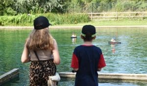 Two children watching radio-controlled model boats on the pond at Wicksteed Park