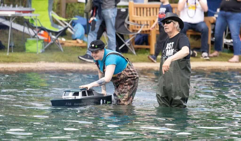 Club members launching a model boat on the pond at Wicksteed Park