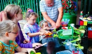 Man and children cutting vegetables outside