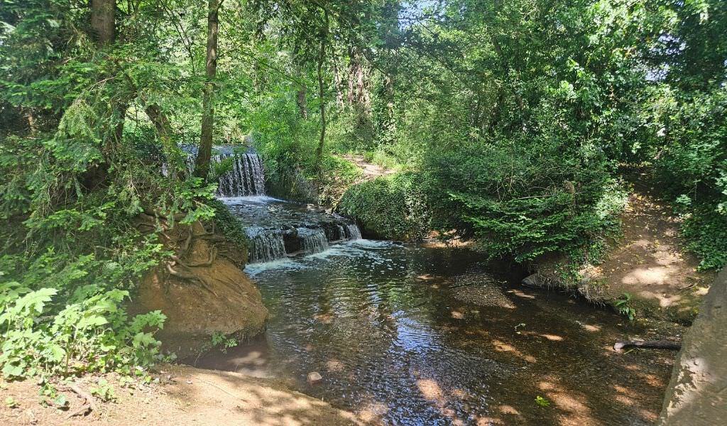 (close-up of waterfall with rocks and dappled light): Small waterfall with stepping rocks in Billing, Northamptonshire