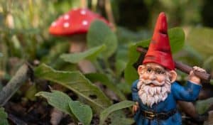 An ornamental mushroom and a gnome hiding in the grass