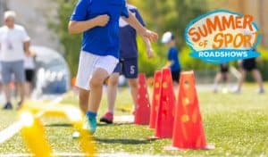 Children running through an agility cone drill outdoors at a Summer of Sport Roadshow event
