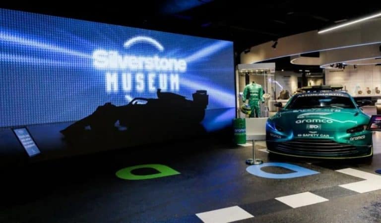 Silverstone Museum entrance display with illuminated Silverstone Museum sign and green Aston Martin Aramco safety car on show