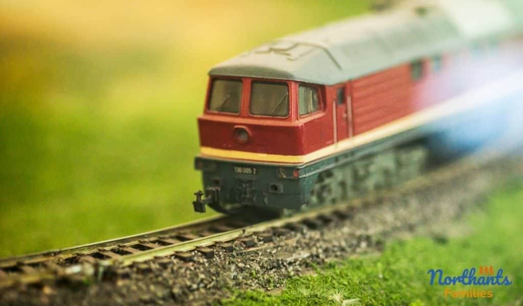 A red model train on a train track