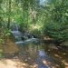 (close-up of waterfall with rocks and dappled light): Small waterfall with stepping rocks in Billing, Northamptonshire